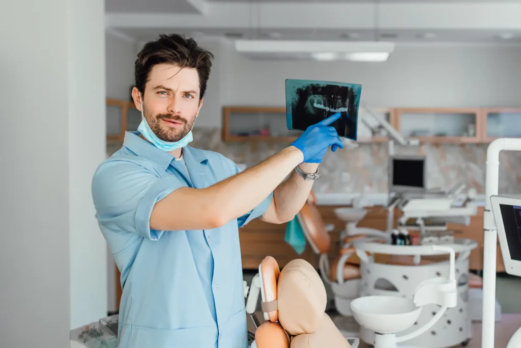 Dentysta w pracy pokazuje zdjęcie rtg.
